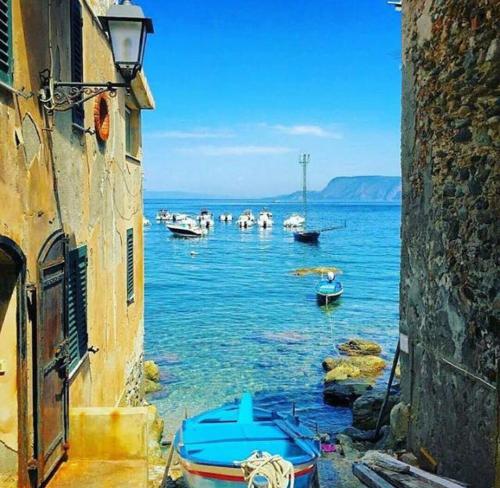 a group of boats in the water between two buildings at Romeo e Giulietta Scilla in Scilla