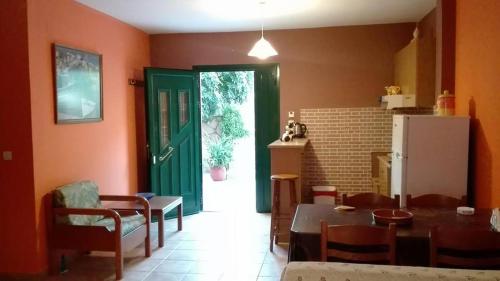 a kitchen with a table and a green door in a room at Anastasis Apartments in Trapezaki