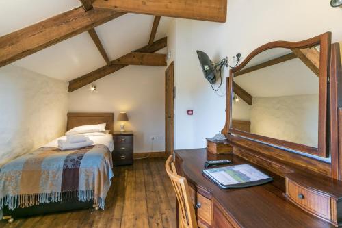 a bedroom with a bed and a large mirror at The Barn B&B in Margam