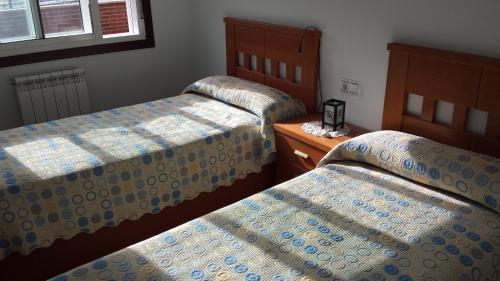 a bedroom with two beds and a nightstand between them at Apartamento O pombal in Cambados