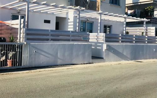 a fence on the side of a road next to a street at MCPlaces Holiday Apartments in Paphos City