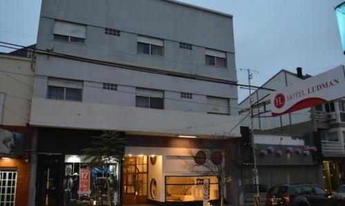 a white building with a sign in front of it at HL Hotel in Cipolletti