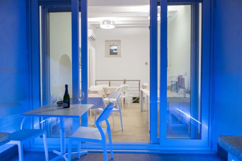 a dining room with blue walls and a table and chairs at Vento di Sicilia in Siracusa