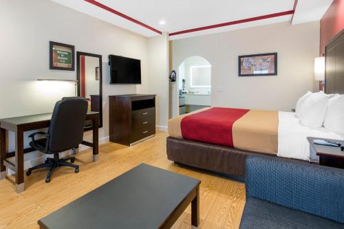 a hotel room with a bed and a desk at Econo Lodge Inn & Suites Houston Willowbrook in Houston