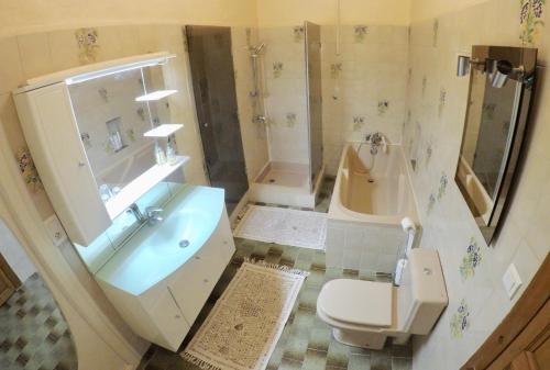 La salle de bains est pourvue d'un lavabo, de toilettes et d'une baignoire. dans l'établissement Le Mas Richard, à Générac