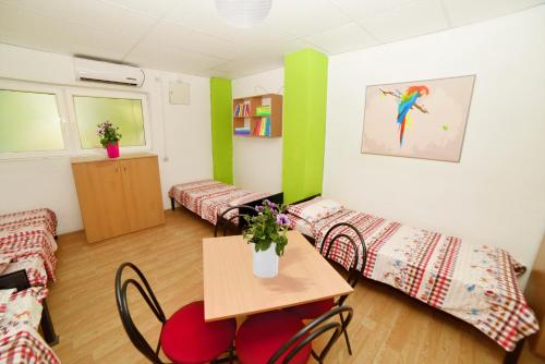 a room with two beds and a table and chairs at HILJADNIKOV Apartments in Štip