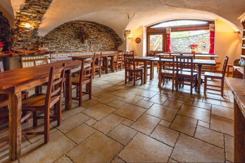 ein Restaurant mit Holztischen und -stühlen in einem Zimmer in der Unterkunft Agriturismo il Fiocco in Cesana Torinese