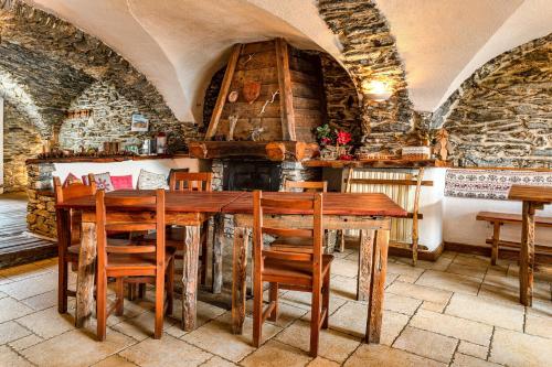 a dining room with a wooden table and chairs at Agriturismo il Fiocco in Cesana Torinese