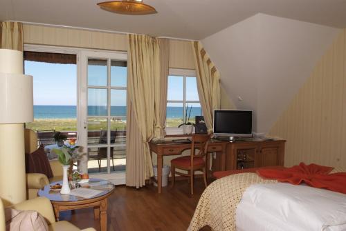a bedroom with a bed and a desk with a computer at Romantik Hotel Namenlos in Ahrenshoop