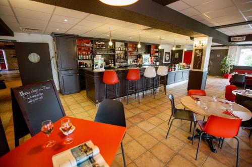 a restaurant with orange chairs and tables and a bar at ibis budget Cherbourg - La Glacerie in Cherbourg en Cotentin
