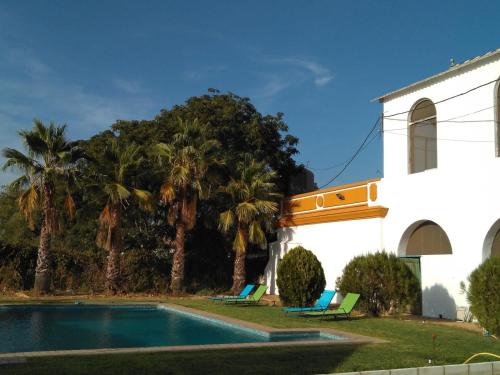 a house with a swimming pool next to a church at Cortijo Santa Clara in Carmona