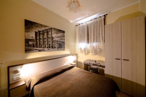 a bedroom with a bed and a painting on the wall at La Belle Epoque in Aosta