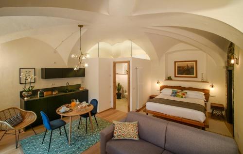 a bedroom with a bed and a table and a couch at Palazzo Giani in Chiavenna