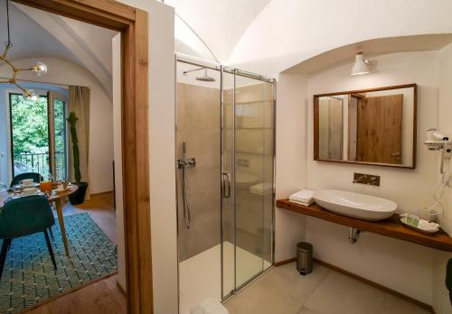 a bathroom with a glass shower and a sink at Palazzo Giani in Chiavenna