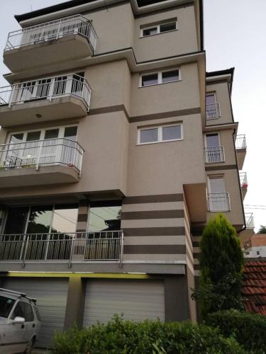 a building with balconies and cars parked in front of it at Aprtments Belma in Sarajevo