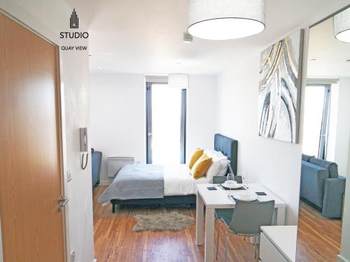 a bedroom with a bed and a desk and a table at Media City Salford Quays in Manchester