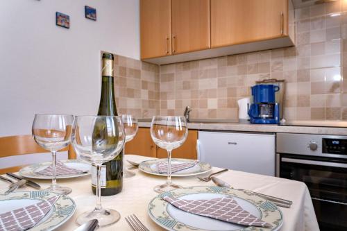 a table with a bottle of wine and glasses on it at Guesthouse Wish in Stari Grad