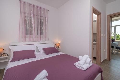 een slaapkamer met een groot bed en handdoeken bij Apartman Niksi in Trogir
