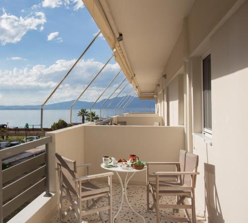 a balcony with a table and chairs and a view of the ocean at Seaside Studios in Áyioi Apóstoloi