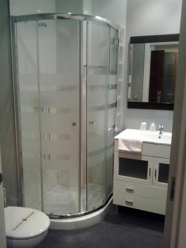 a bathroom with a shower and a toilet and a sink at Hostal San Sebastian Centro in San Sebastián