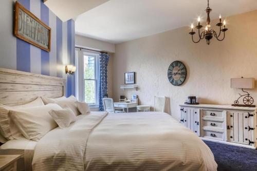a bedroom with a large white bed and a desk at Patterson Inn in Denver