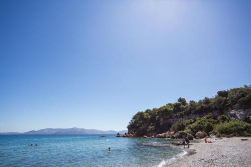 a beach with a bunch of people in the water at Seaside Studios in Áyioi Apóstoloi