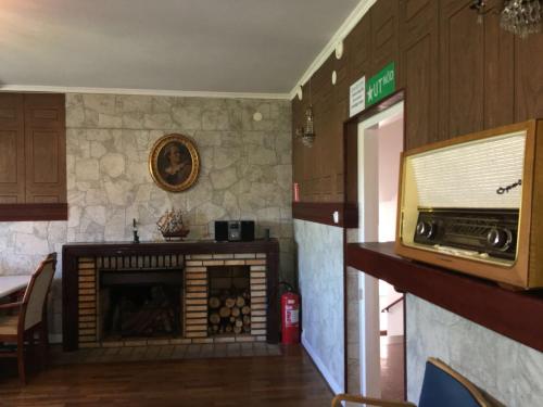 a living room with a fireplace and a microwave at Grums Old House in Grums