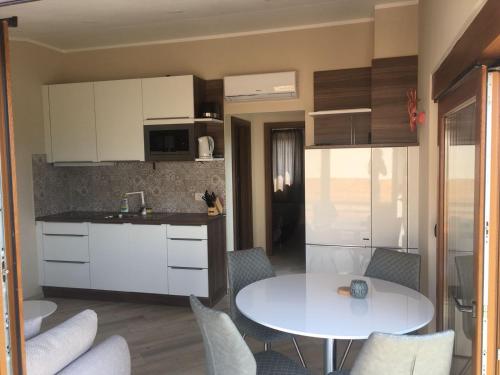 une cuisine avec une table blanche, une table et des chaises dans l'établissement Masanda Luxury Apartments, à Dobropoljana