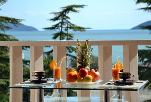 a plate of fruit on a glass table on a balcony at Montesun Residence in Herceg-Novi