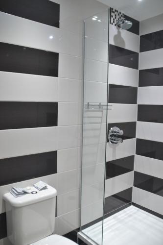 a bathroom with a toilet and a glass shower at Hotel 65 in London