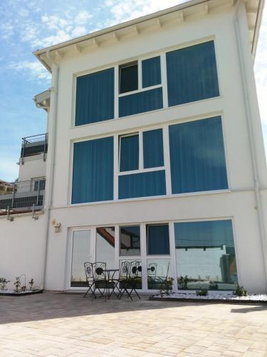una casa con ventanas de cristal y sillas frente a ella en Haus VITALIS - Guesthouse Burgenland, en Sigless