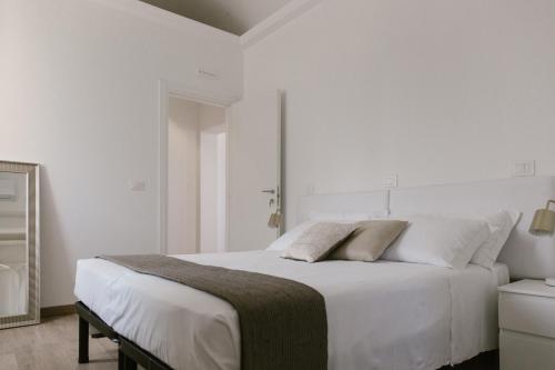 a white bedroom with a large bed with white walls at Stazione a mare in Casalbordino