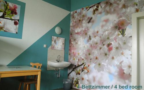 łazienka z umywalką i kwiatami na ścianie w obiekcie Hostel kangaroo-stop w Dreźnie