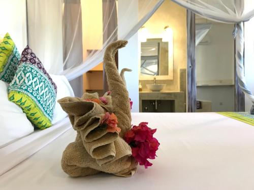 a stuffed animal is sitting on a bed at Villa Huruma in Paje