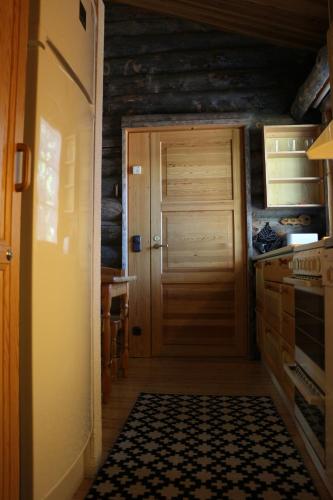 - une cuisine avec une porte en bois et une cuisinière dans l'établissement Avatar Kelo Cottage, à Ruka