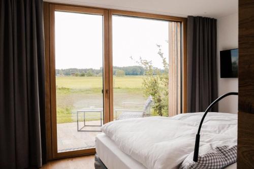 a bedroom with a bed and a sliding glass door at Hotel Lenderstuben in Balzhausen