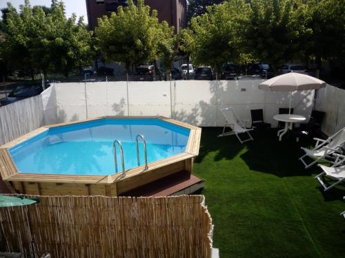 a hot tub in a yard with a table and chairs at Hotel Antonella in Lido di Classe