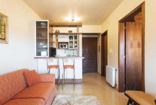 sala de estar con sofá y cocina en Belo apartamento e completo no Centro com vista, en Gramado