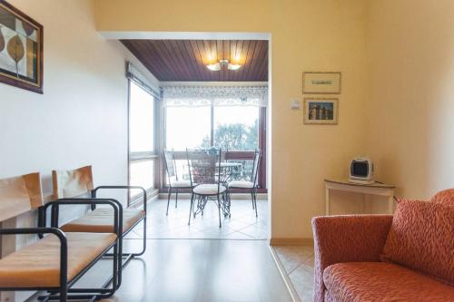 sala de estar con sofá, mesa y sillas en Belo apartamento e completo no Centro com vista, en Gramado