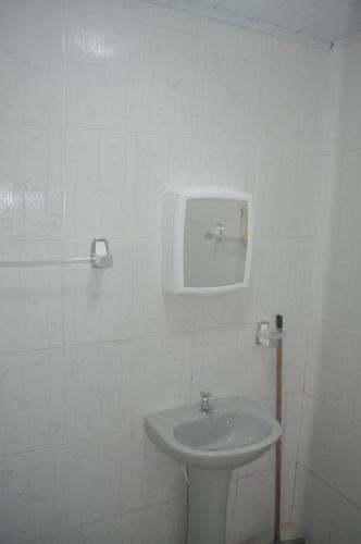 um banheiro branco com uma pia e um espelho em Sitio Os Tres em Camaçari