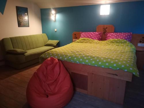 a bedroom with a bed and a couch at Apartma PR PEKOVCU in Bohinj
