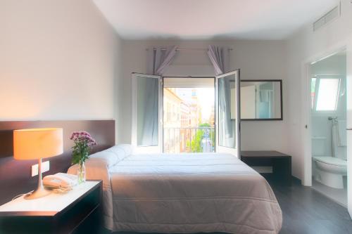 una camera con letto e finestra e un bagno di Hotel Madrid de Sevilla a Siviglia