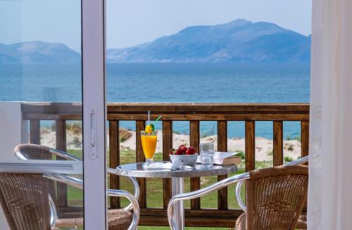 a table with drinks on a balcony with a view of the ocean at Gaia Royal in Mastichari