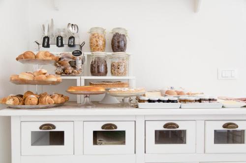 un mostrador blanco con varios tipos de pan y repostería en aMarti Suites B&B, en Santo Stefano di Magra