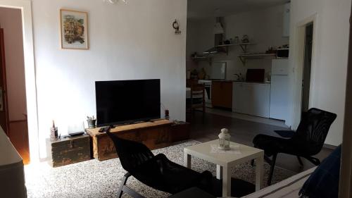 a living room with a tv and two chairs and a table at Holiday Home Shangri-La in Milna