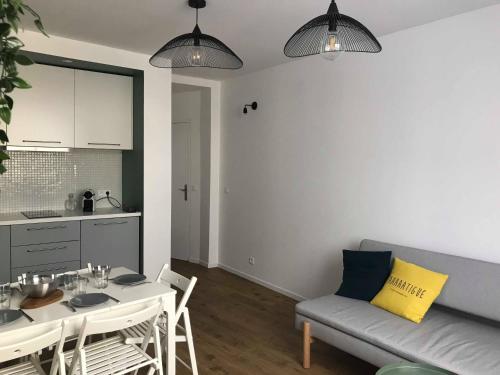 eine Küche und ein Wohnzimmer mit einem Tisch und einem Sofa in der Unterkunft Le pénéquet : L'appartement du vieux port ☺ in Marseille