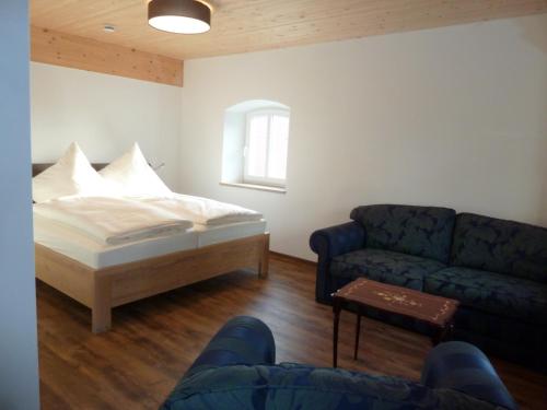 a living room with a bed and a couch at Ferienwohnung zum Dorfwirt in Riedenburg