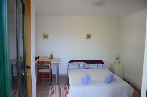 Un dormitorio con una cama con almohadas azules. en Apartmani Gale, en Okrug Donji