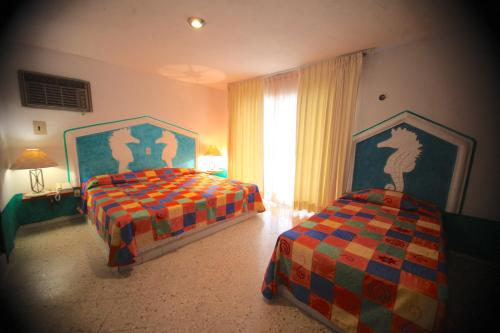 1 Schlafzimmer mit 2 Betten und einem Fenster in der Unterkunft Hotel Carrillos Cancun in Cancún