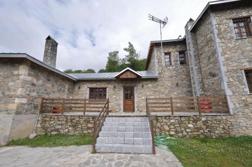 an old stone building with stairs in front of it at Manis Hotel in Nimfaíon